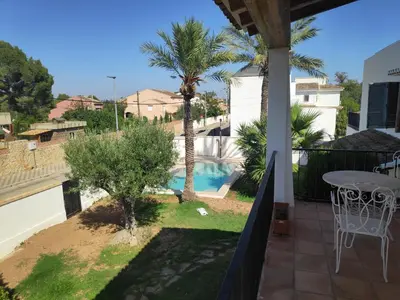 a balcony with a table and a palm tree at La Casa del Sol in La Eliana