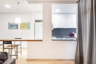 a kitchen with white cabinets and a table with chairs at Centrico, 2 habitaciones, confort ascensor,wifi AC in Valencia