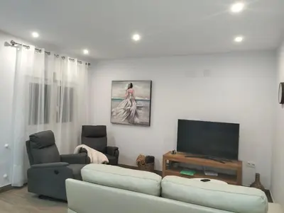 a living room with a couch and a flat screen tv at Casa Bonita de Gisela in Puerto de Sagunto