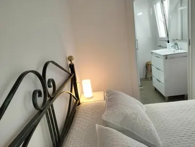 a bedroom with a bed with a lamp and a sink at Casa Bonita de Gisela in Puerto de Sagunto