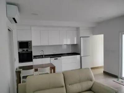 a living room with a couch and a kitchen at Casa Bonita de Gisela in Puerto de Sagunto