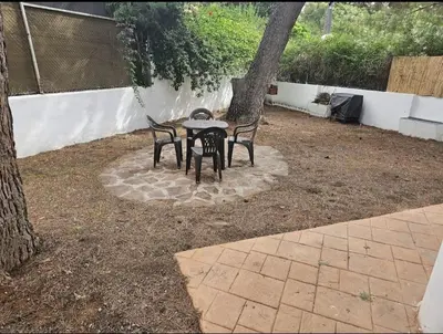 a table and two chairs sitting next to a tree at La Cañada in Partida de La Cañada
