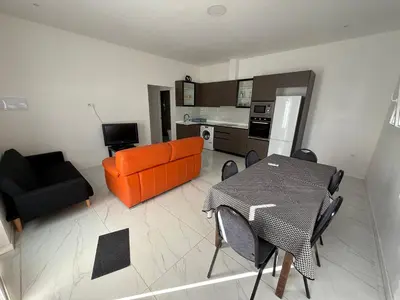 a living room with an orange couch and a table at Apartamento Sara - Alquiler de temporada in Puerto de Sagunto