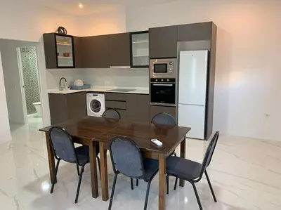 a kitchen with a wooden table and four chairs at Apartamento Sara - Alquiler de temporada in Puerto de Sagunto
