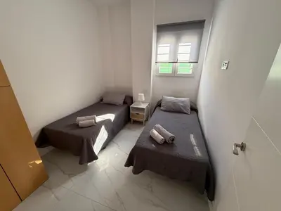 a room with two beds and a window at Apartamento Sara - Alquiler de temporada in Puerto de Sagunto