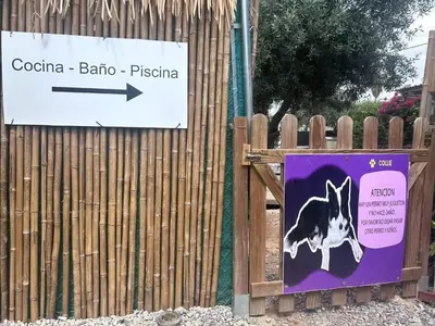 a sign on a fence with a dog on it at J&L Glamping in La Presa