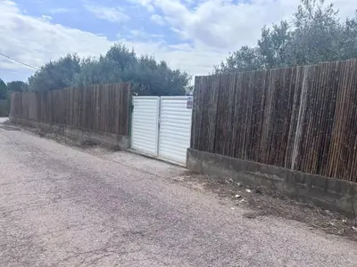 a fence on the side of a road next to a gate at J&L Glamping in La Presa