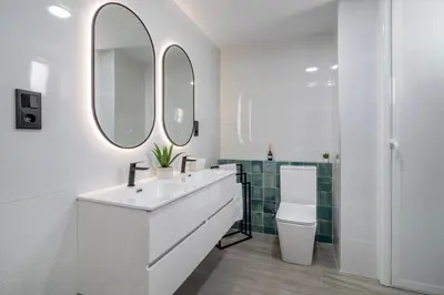 a white bathroom with a sink and two mirrors at SingularStays Santa Clara II in Valencia