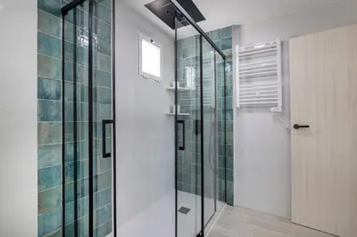 a bathroom with a shower with green tiles at SingularStays Santa Clara II in Valencia