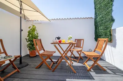 a table and chairs on a patio with an umbrella at SingularStays Santa Clara II in Valencia