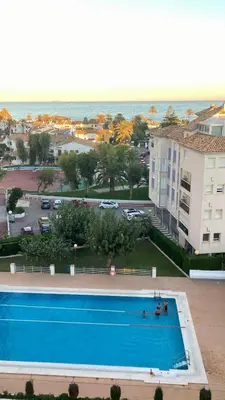 a large swimming pool next to a building and the ocean at Panorama Azul Apartment in El Puig