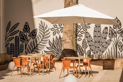 a restaurant with tables and chairs and an umbrella at BYPILLOW Sinfonía in Valencia