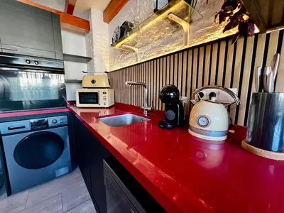 a kitchen with a red counter top with a sink at Luxury penthouse center appartement in Valencia