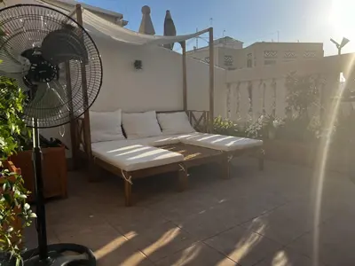 a couch sitting on a balcony with a fan at Luxury penthouse center appartement in Valencia