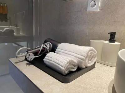 a bathroom with a blow dryer and towels on a counter at Osito Hub - Campoamor in Valencia