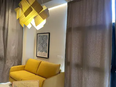 a living room with a yellow couch and a window at Osito Hub - Campoamor in Valencia