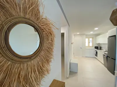 a round mirror on a wall in a kitchen at Travel Habitat Playa Puzol con encanto in Puzol