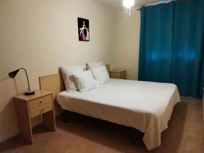 a bedroom with a bed and a blue curtain at Apartamento cerca del puerto deportivo 1 in Burriana