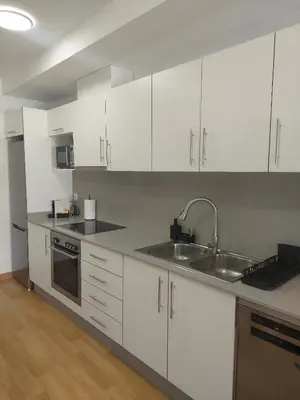 a kitchen with white cabinets and a sink at Cozy apartment near the beach in Puerto de Sagunto