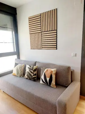 a couch with pillows on it in a living room at Cozy apartment near the beach in Puerto de Sagunto