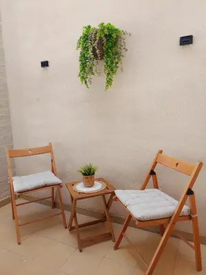 two chairs and a table with a plant on a wall at Cozy apartment near the beach in Puerto de Sagunto