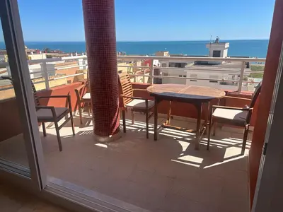 a balcony with a table and chairs and a view of the ocean at Appartement Tavernes de la Valldigna 4p in Valencia