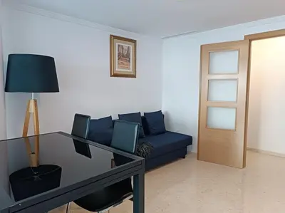 a living room with a blue couch and a table at Gilet senderismo bici parking 20 min Valencia in Gilet
