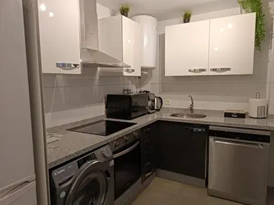 a kitchen with a stove top oven next to a washing machine at Gilet senderismo bici parking 20 min Valencia in Gilet