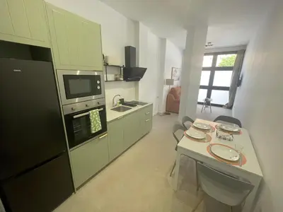 a kitchen with a black refrigerator and a table at Galdós Flats by Vivo GC in Valencia