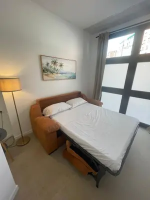 a bedroom with a bed and a couch and a window at Galdós Flats by Vivo GC in Valencia