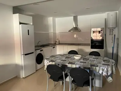 a kitchen with a table and chairs and a refrigerator at VIVIENDA La MERCED in El Puig