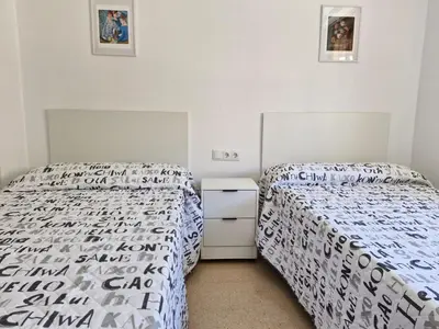 two beds in a small bedroom with white walls at VIVIENDA La MERCED in El Puig