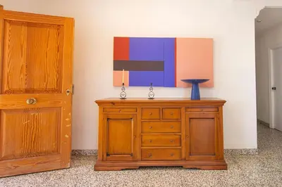 a wooden dresser with a painting on the wall next to a door at Villa Azahar - Piscina - Barbacoa - Naturaleza in Valencia