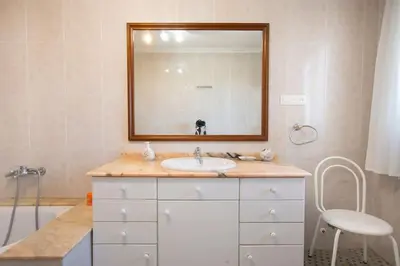 a bathroom with a sink and a mirror and a tub at Villa Azahar - Piscina - Barbacoa - Naturaleza in Valencia