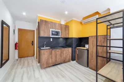 a kitchen with wooden cabinets and a bunk bed at Albufera Dreams Nature Suites in Valencia
