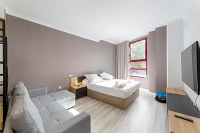 a bedroom with a bed and a couch and a tv at Albufera Dreams Nature Suites in Valencia