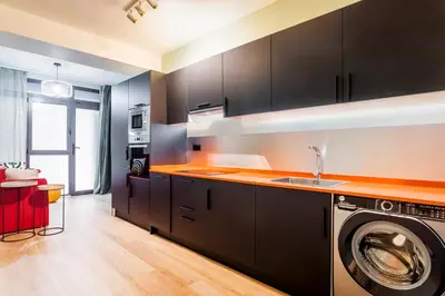 a kitchen with black cabinets and a washing machine at Apartamento B Cube by Mimood Aparthotels in Valencia