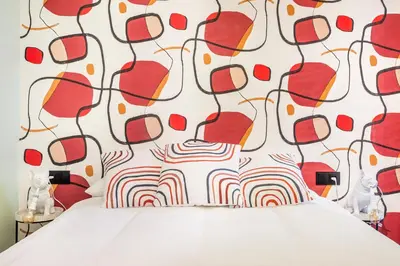 a bedroom with a bed with a red and white wall at Apartamento B Cube by Mimood Aparthotels in Valencia
