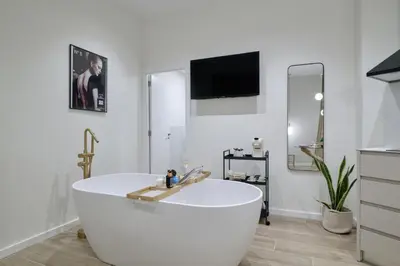 a white bath tub in a bathroom with a tv at Romantic Apartment N1 Oceanografico Virkin Suites in Valencia