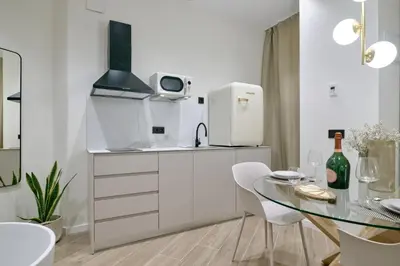 a kitchen with a glass table and a refrigerator at Romantic Apartment N1 Oceanografico Virkin Suites in Valencia
