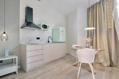 a kitchen with a sink and a table with a chair at Romantic Apartment N2 Oceanografico Virkin Suites in Valencia