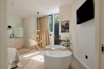 a white living room with a table and a kitchen at Romantic Apartment N2 Oceanografico Virkin Suites in Valencia