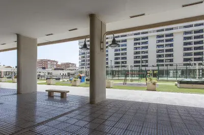a room with a bench in the middle of a building at ApartUP Patacona Palm Beach II in Valencia