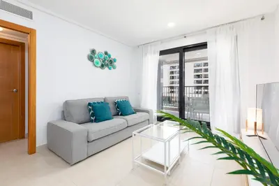 a living room with a couch and a glass table at ApartUP Patacona Palm Beach II in Valencia