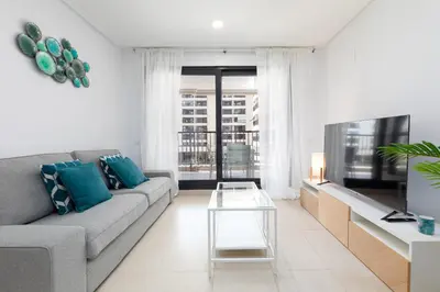 a living room with a couch and a table at ApartUP Patacona Palm Beach II in Valencia