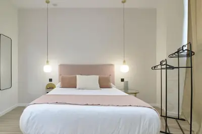 a bedroom with a large white bed with two lights at Romantic Apartment N3 Oceanografico Virkin Suites in Valencia