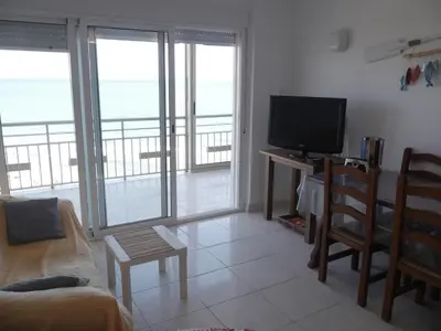 a living room with a television and a balcony with the ocean at HAWAI, Esc-3, 3-16 in Faro de Cullera