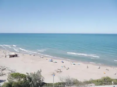 a beach with a lot of people and the ocean at HAWAI, Esc-3, 3-16 in Faro de Cullera