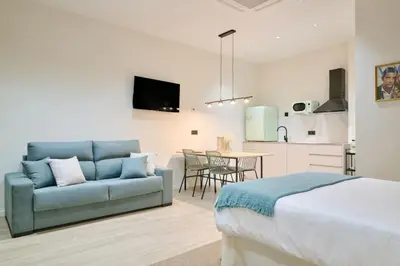 a bedroom with a couch and a kitchen with a table at Romantic Apartment N.4 Oceanografico Virkin Suites in Valencia