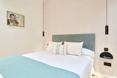 a bedroom with a white bed with a blue blanket at Romantic Apartment N.4 Oceanografico Virkin Suites in Valencia